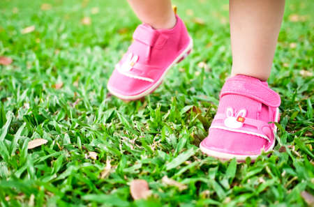 Baby taking her small steps on green grassの写真素材