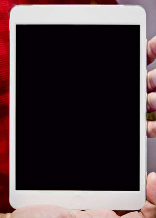 Hand holding white body tablet computer showing black screenの写真素材