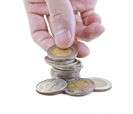Hand stacking up Thai coins isolated on white  Abstract of money growing or saving の写真素材