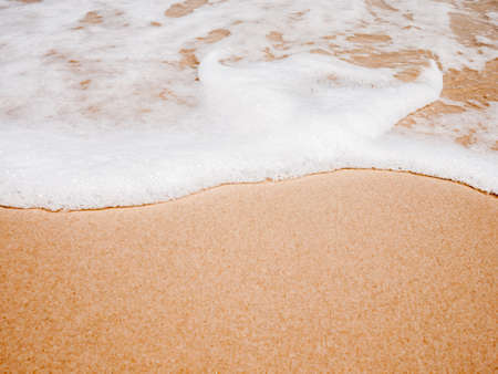 Clean and white wave on the beach with the smooth sand. Remembrance of the last summer trip.