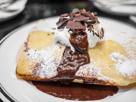 Sweet dessert chocolate crepe isolated on white plateの写真素材