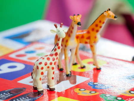 Plastic giraffe toy isolated on colorful background for playful kidsの写真素材