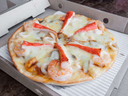 Seafood pizza delivered in the paper boxの写真素材