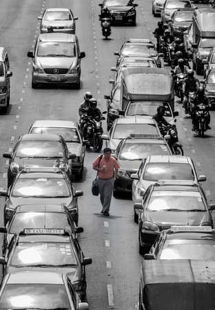 BANGKOK, THAILAND - MAY 30: Unidentified businessman walking in the middle of the bad traffic road...