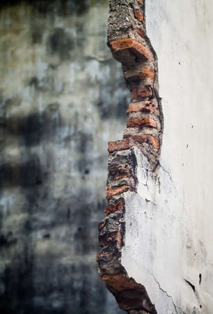 Damaged wall showing bricks with grunge background