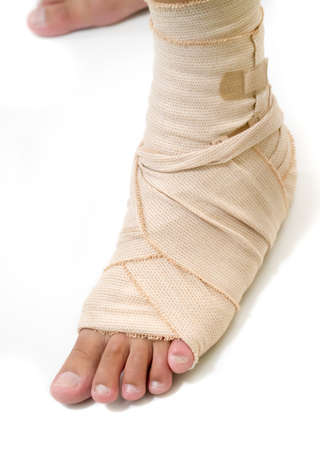 First-aid the injured foot using bandage isolated on white の写真素材