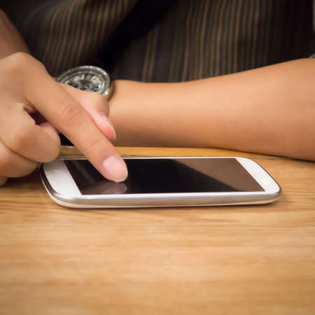 People using a smartphone on wooden table symbolize of the mobile technology age