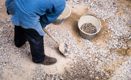 Worker gathering stone to mix the concrete in construction areaの写真素材