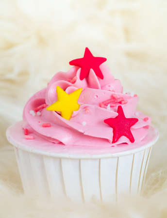 Sweet pink cupcake with stars on soft fur backgroundの写真素材