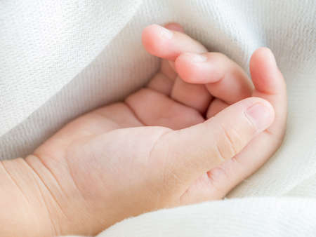 Child's hand is laying down while sleeping in concept of love and careの写真素材