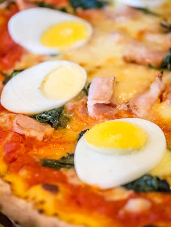 Closeup shot of boiled egg topped homemade pizzaの写真素材