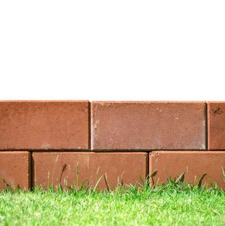 Brick layers on green grass leaving white space on top