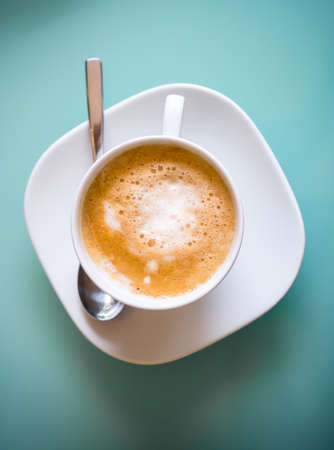 Hot latte coffee with strong shadow in concept of unhealthy foodの写真素材