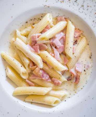 Penna carbonara with ham and bacon from top viewの写真素材