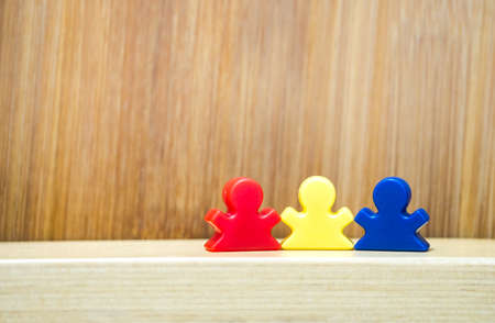 Three meeples on wooden background in concept of family game