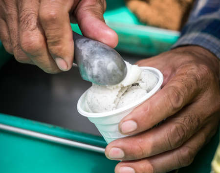 Hand holding cup of coconut ice cream from bangkok street foodの写真素材