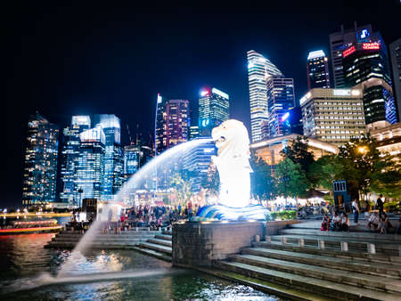 SINGAPORE - AUGUST 24, 2016 : The Merlion fountain in front of business buildings at night of Marina Bay in Singaporeのeditorial素材