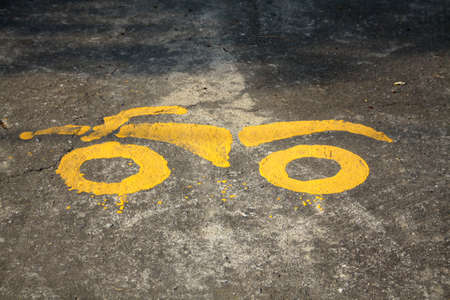 yellow paint of motorcycle parking symbol on floorの写真素材