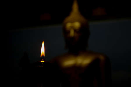 old brass lamp, lantern, candle light on night with blur of buddha