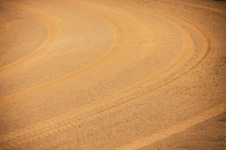 texture curve wheel track on orange soil and sand roadの写真素材