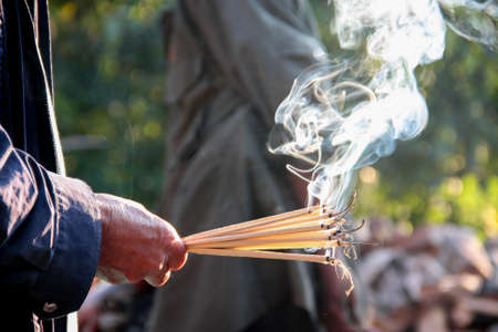 hand holding incense sticks for worship, praying god of Asia religionの写真素材