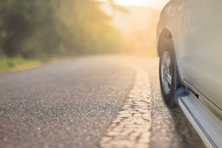 front side of car on old asphalt road and sunset, travel conceptの写真素材