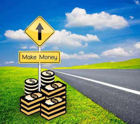 make money pole sign, go ahead with road on green grass and blue skyの写真素材