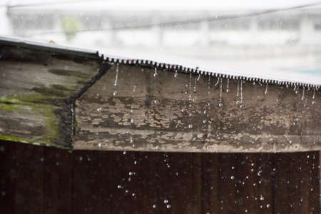 water falling from old roof in rainy dayの写真素材