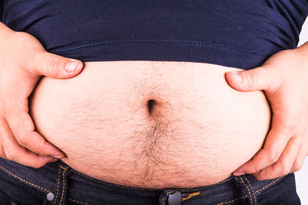 Man touching his fat belly on white backgroundの写真素材