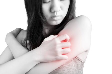 Scratching her arm or shoulder in a woman isolated on white background.