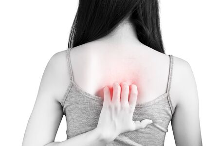 Scratching her back in a woman isolated on white background.