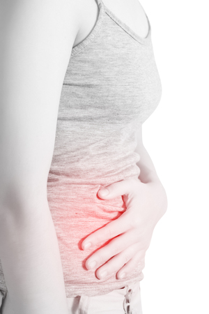 Stomachache in a woman isolated on white background.の写真素材