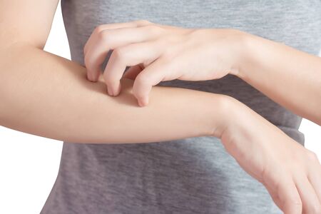 Scratching her arm in a woman isolated on white background.