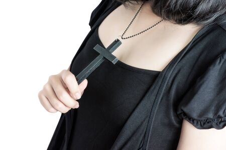 Beautiful asia woman with hopeful holding christian symbol of crucifix praying to God isolated on white background.の写真素材