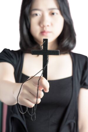 Beautiful asia woman with hopeful holding christian symbol of crucifix praying to God isolated on white background.の写真素材