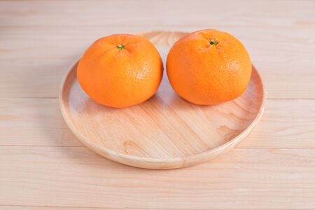 Top view accessories Chinese new year festival decorations.orange,leaf,wood dish,red packet,plum blossom, on wood backgroundの写真素材