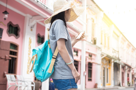 Young Asian traveling blogger or backpacker using route application on the mobile phone  to find the needed address in a city phuket, Thailandの写真素材