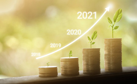 Growth in 2021 year concept. Business graph with arrow up. Growing money coins stack.の写真素材