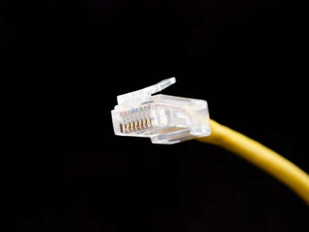 yellow network cable, isolated on black backgroundの写真素材