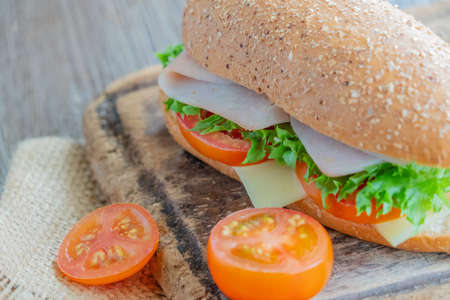 sandwiches with ham, tomatoes, cheese burger and vegetables on cooking tableの写真素材