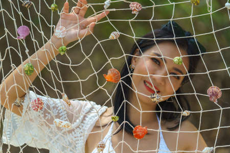 Portrait of woman posing outdoors at the sea beachの写真素材