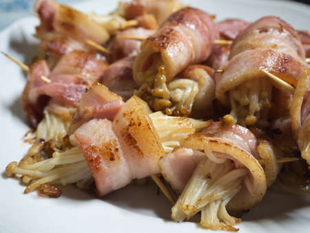fried Bacon wrap Golden Needle mushroomの写真素材