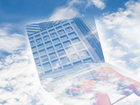 double exposure hand on notebook and building screen on blue skyの写真素材