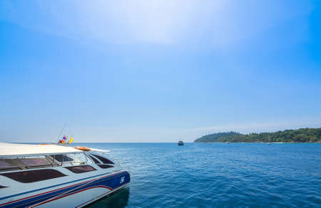 speed boat going to island over blue sky