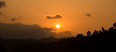 silhouette sunset behind mountain and orange sky