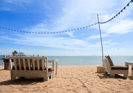 Wooden Chairs and table relax time on the beach with cloud and blue sky