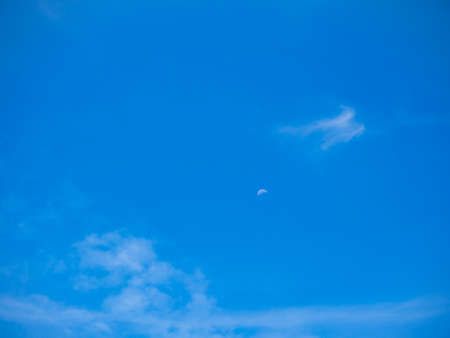 cloudscape blue sky and mini half moon on sunny dayの写真素材