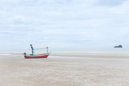 longtail boat on the beach over blue sky in cloudy dayの写真素材