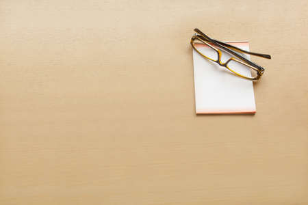 office desk with eye glasses and paper noteの写真素材