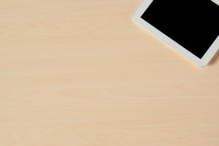 Copy space on wooden table with tablet on cornerの写真素材